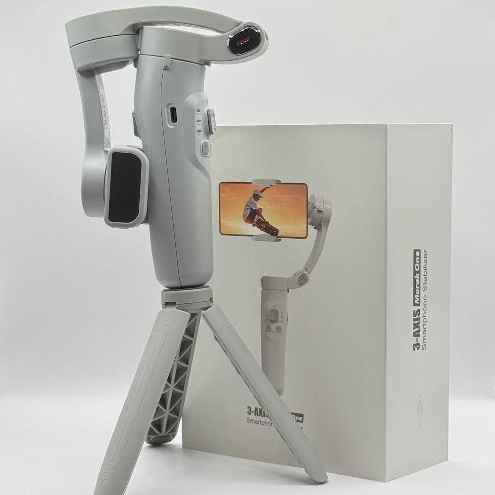 Grey 3-AXIS Merak One smartphone gimbal stabilizer standing on tripod beside its retail packaging box