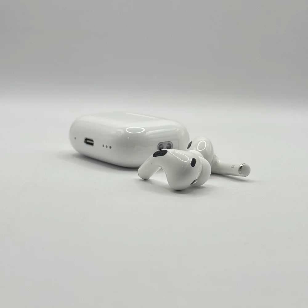 Close up view of AirPods Pro 2 ear-tips and charging case on plain background