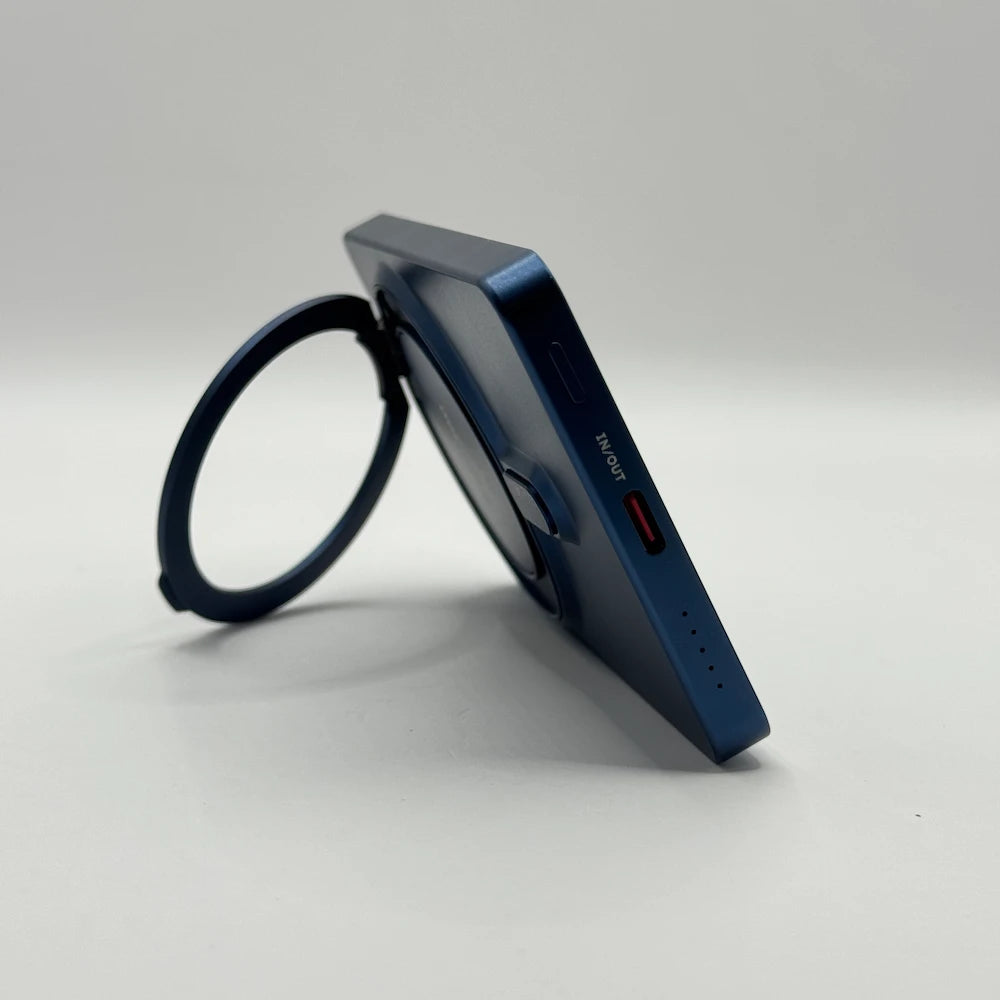 Side profile of behagen magnetic power bank resting on open ring stand displaying USB-C IN OUT port and LED battery dots