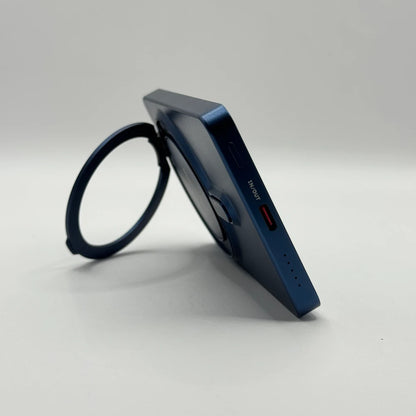 Side profile of behagen magnetic power bank resting on open ring stand displaying USB-C IN OUT port and LED battery dots