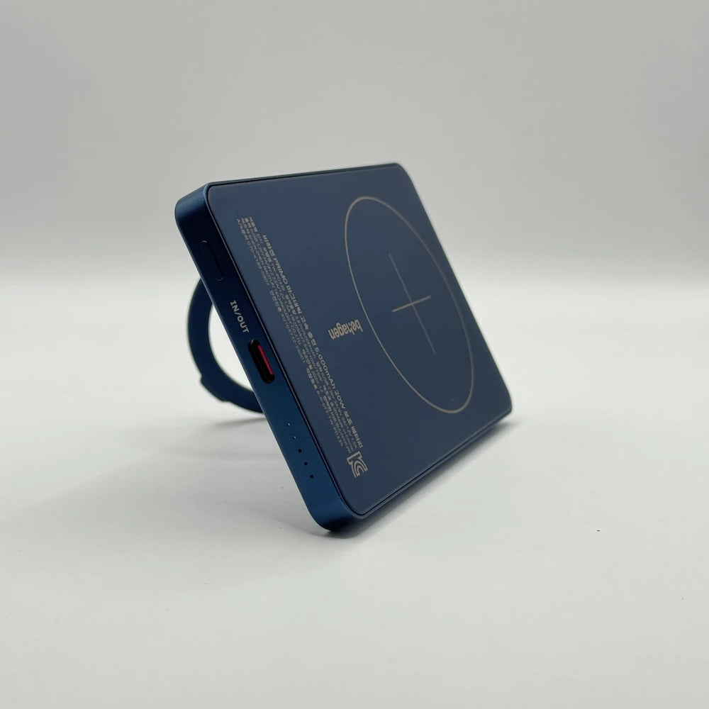 Angled front view of metallic blue behagen wireless power bank supported vertically by its built-in ring stand