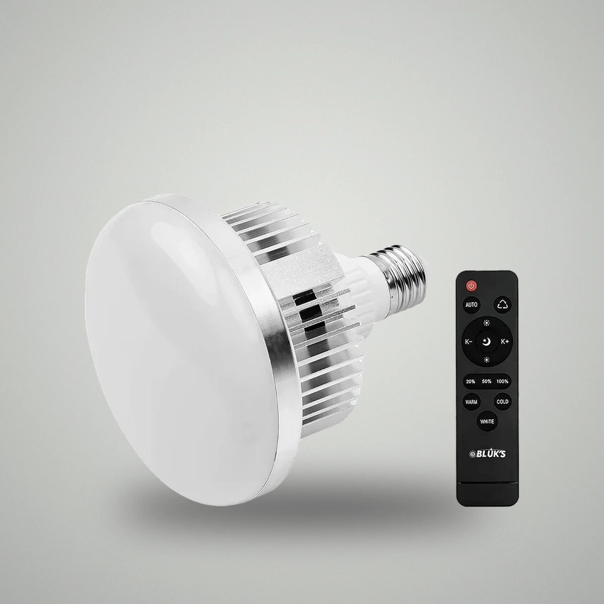Perspective view of BLUK'S E27 studio LED light bulb alongside black wireless remote controller