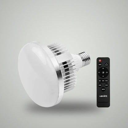 Perspective view of BLUK'S E27 studio LED light bulb alongside black wireless remote controller