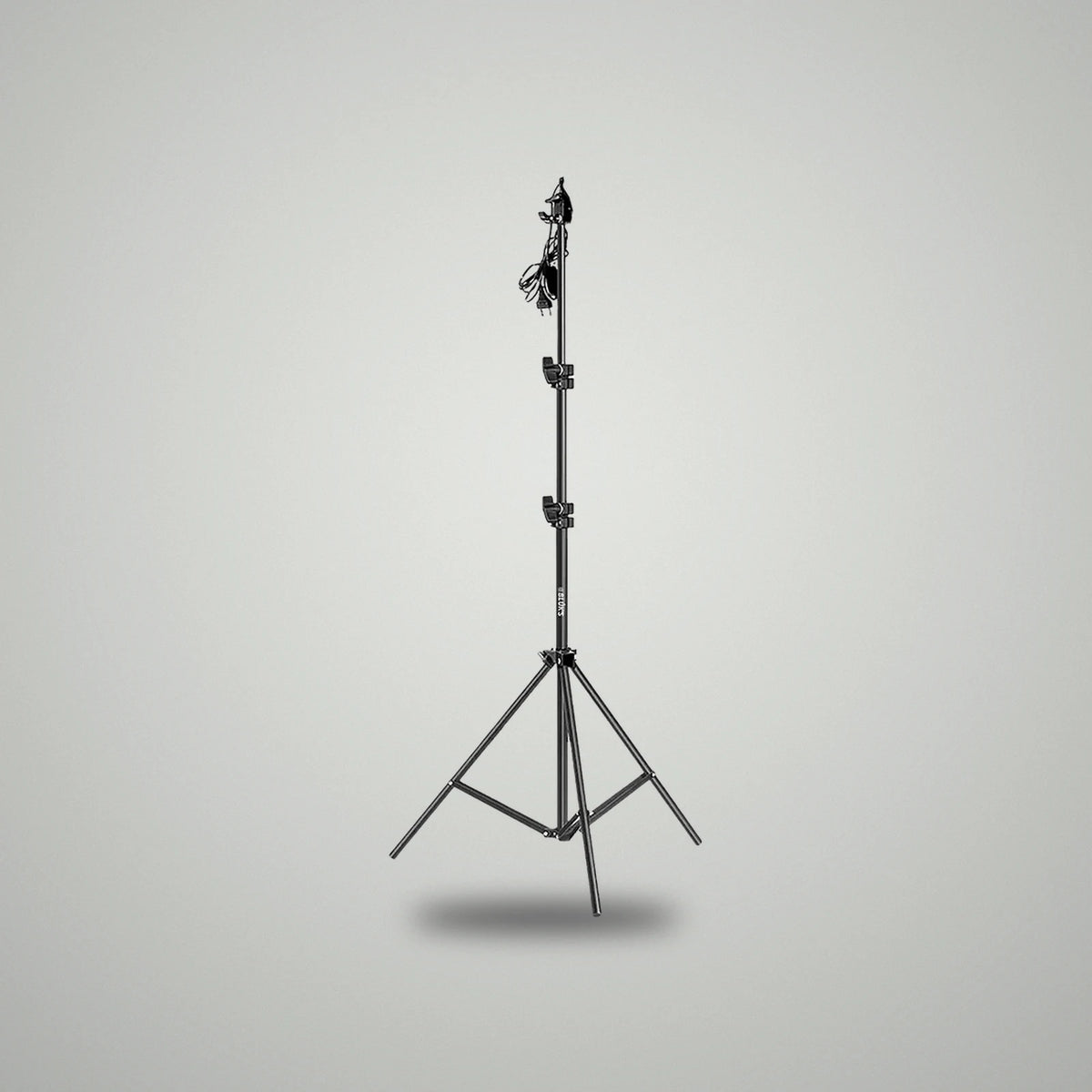 Full height view of BLUK'S black metallic adjustable studio light stand with power cable attached