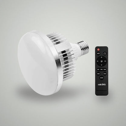 Perspective view of BLUK'S E27 studio LED light bulb alongside black wireless remote controller