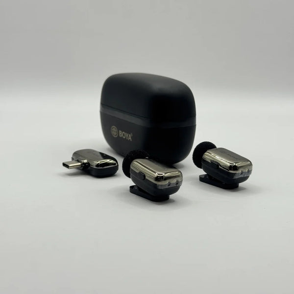 Two chrome-accented BOYA BY-MW10 clip-on wireless transmitter mics and 2-in-1 receiver adapter placed in front of charging case