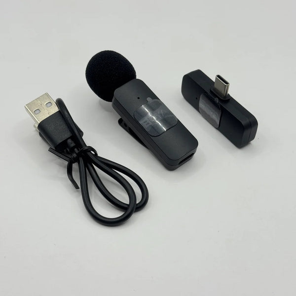 Unboxed BOYA BY-V10 wireless lavalier mic transmitter with foam windscreen, USB-C receiver dongle, and USB charging cable