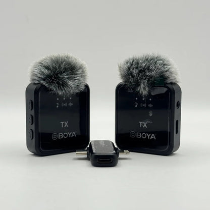 Frontal view of twin BY-V20 wireless transmitter units with furry windscreens and dual plug receiver adapter