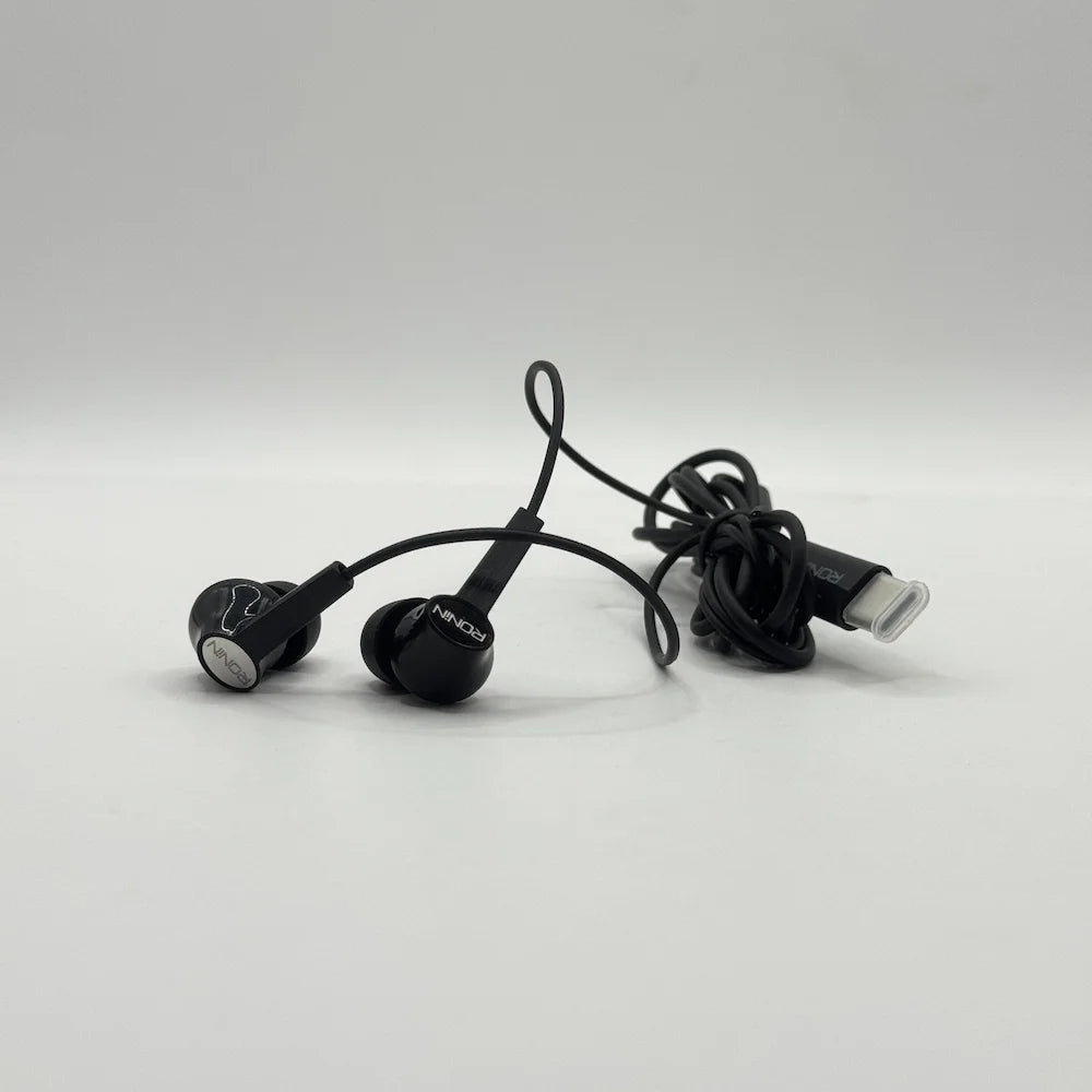 Close up view of Ronin R-29 Stellar black earpieces and protective Type-C connector cap