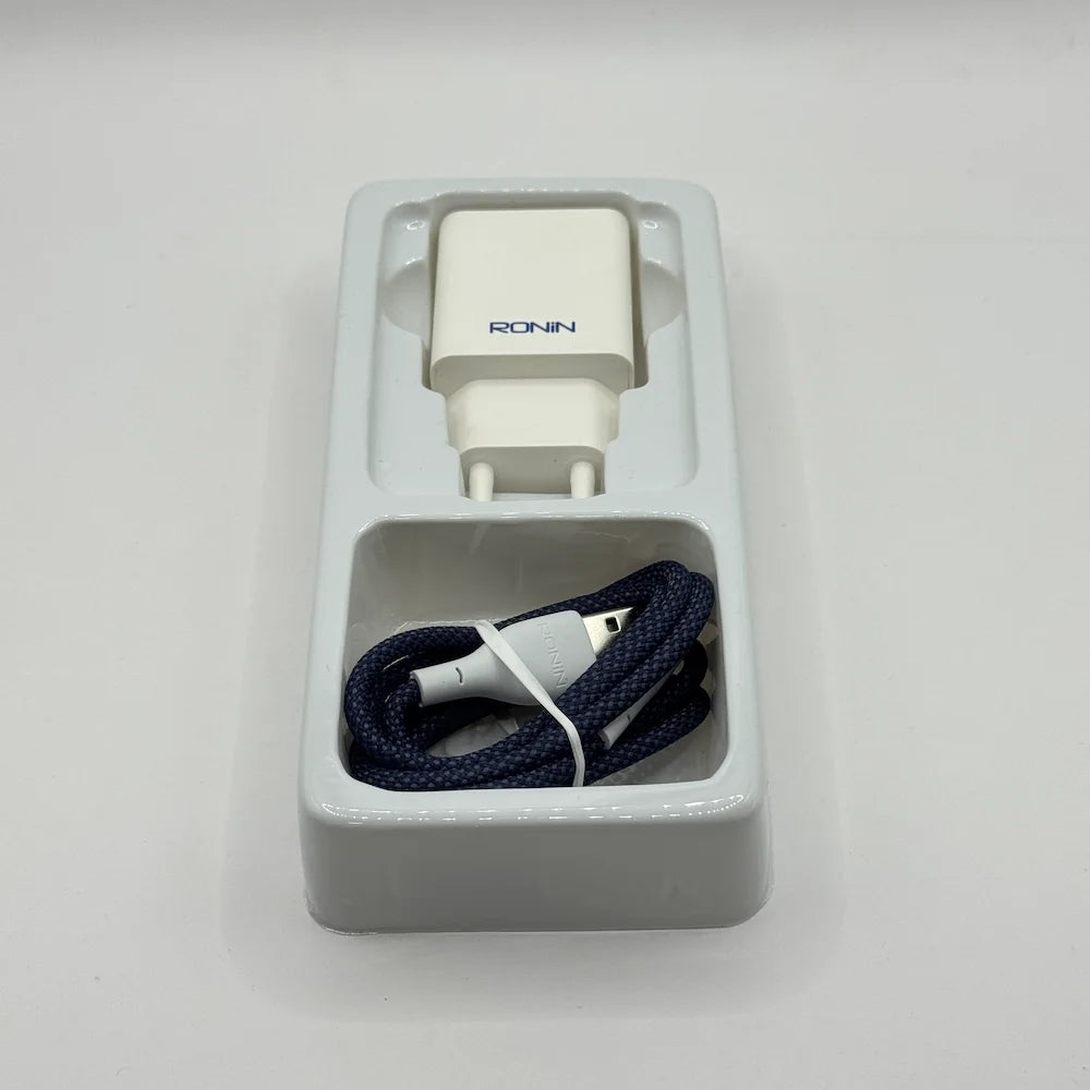 Ronin R-615 Encore white adapter and blue braided charging cable resting inside inner plastic packaging tray