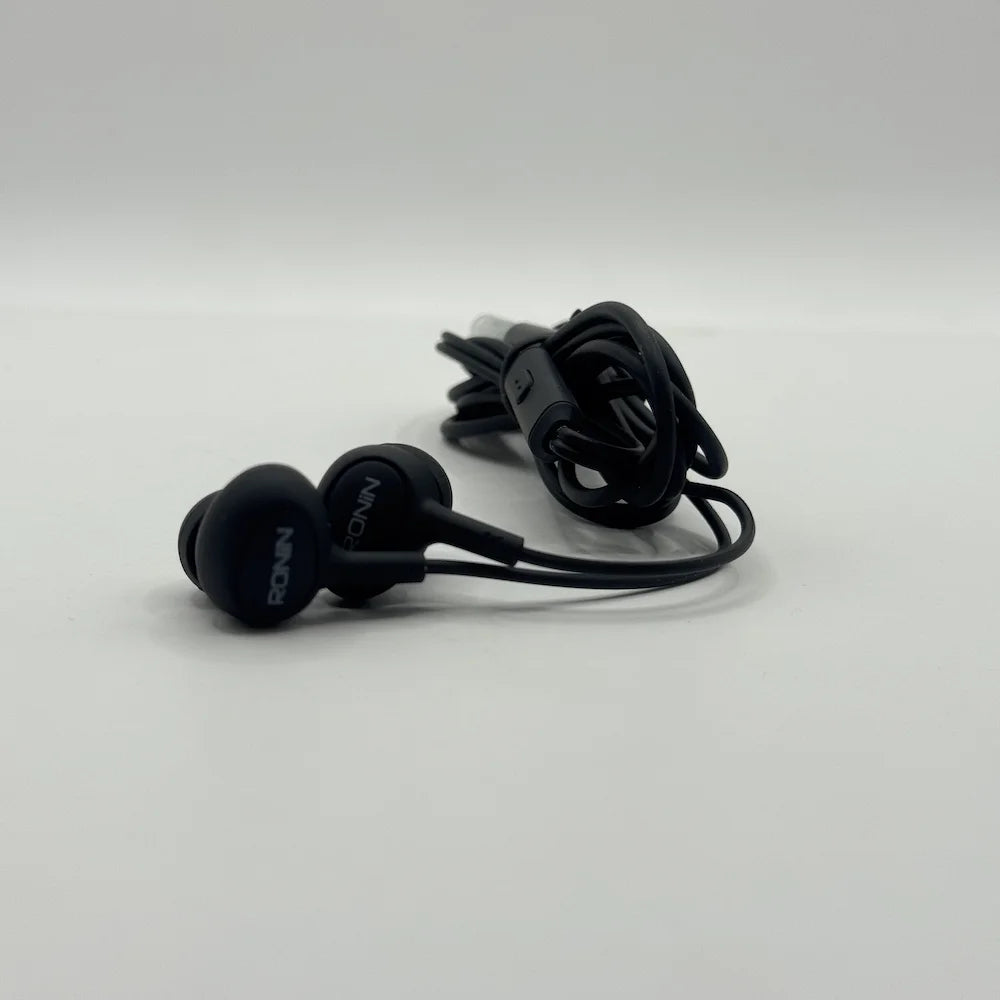 Close up view of Ronin R-9 black earpieces resting beside inline microphone controller